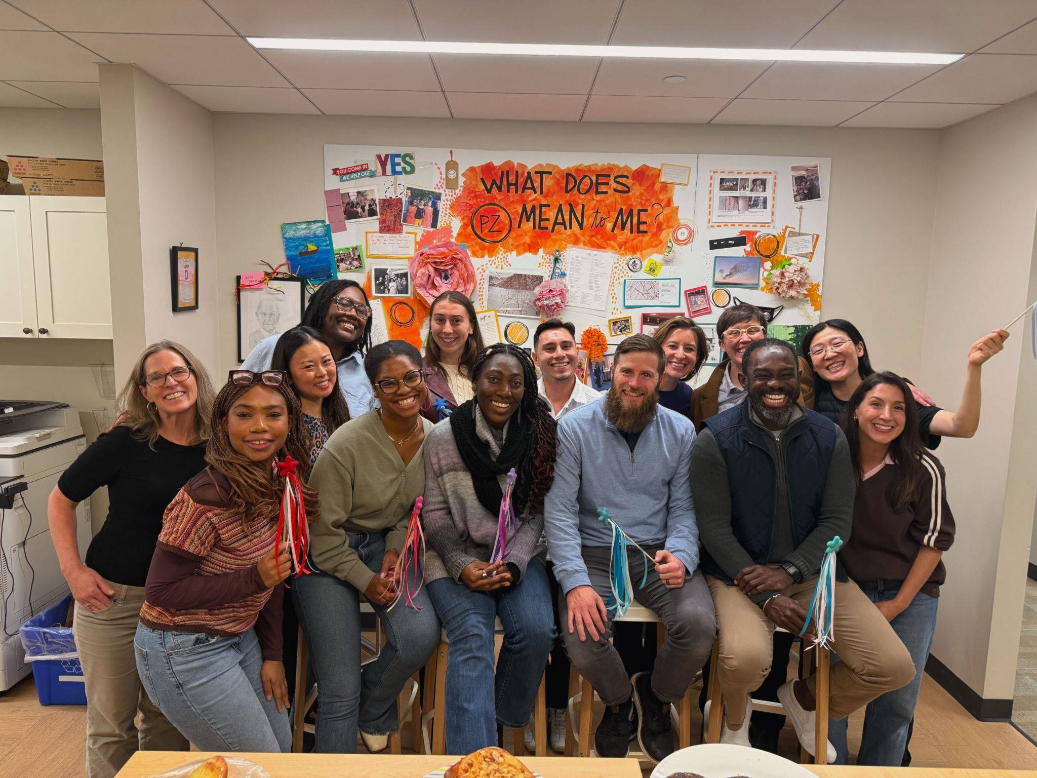 Group of people smiling together and holding magic wands.