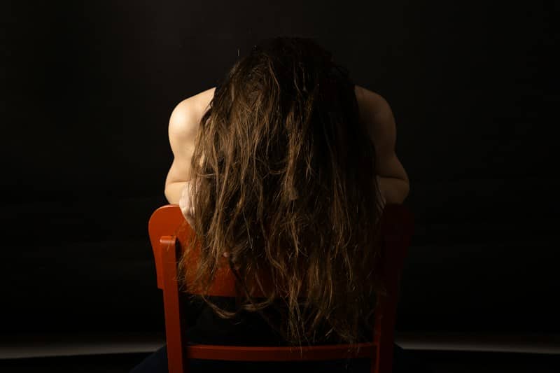 Woman with long brown hair on red chair