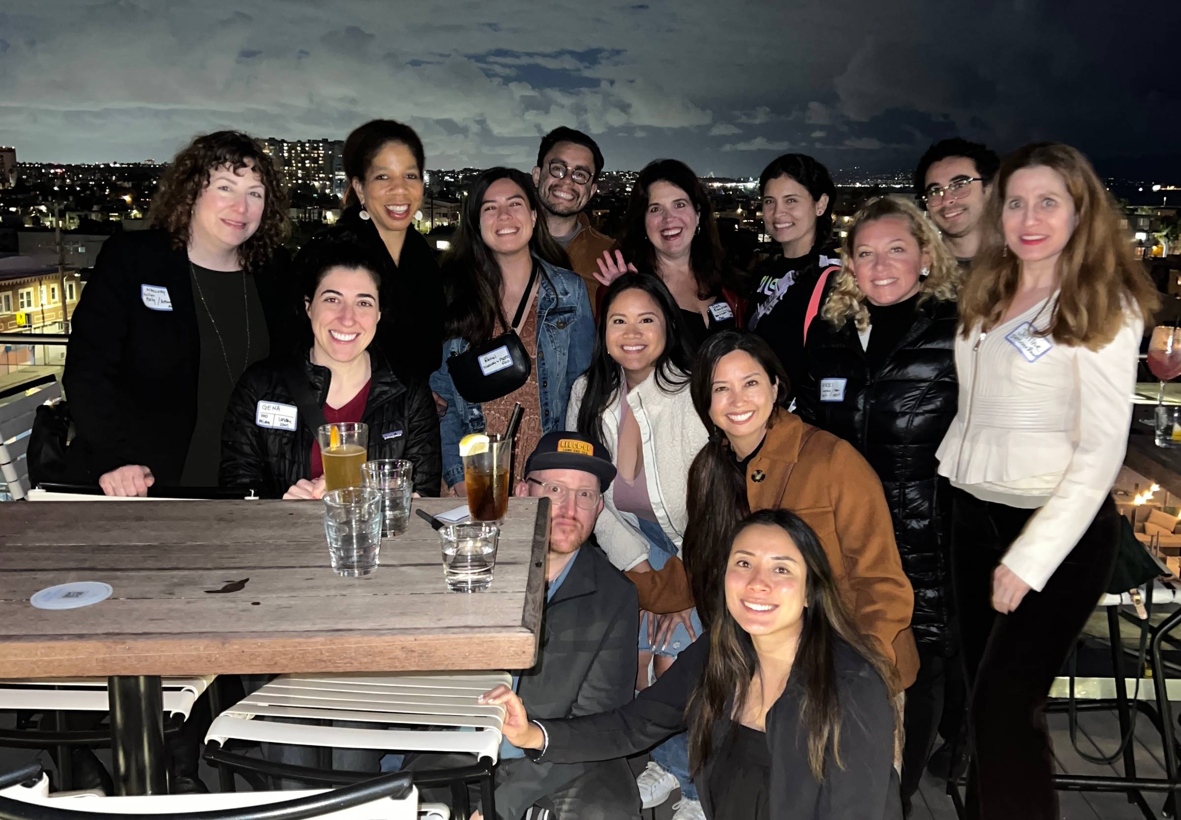 travel lovers gathered at a bar smiling at the camera and talking about travel