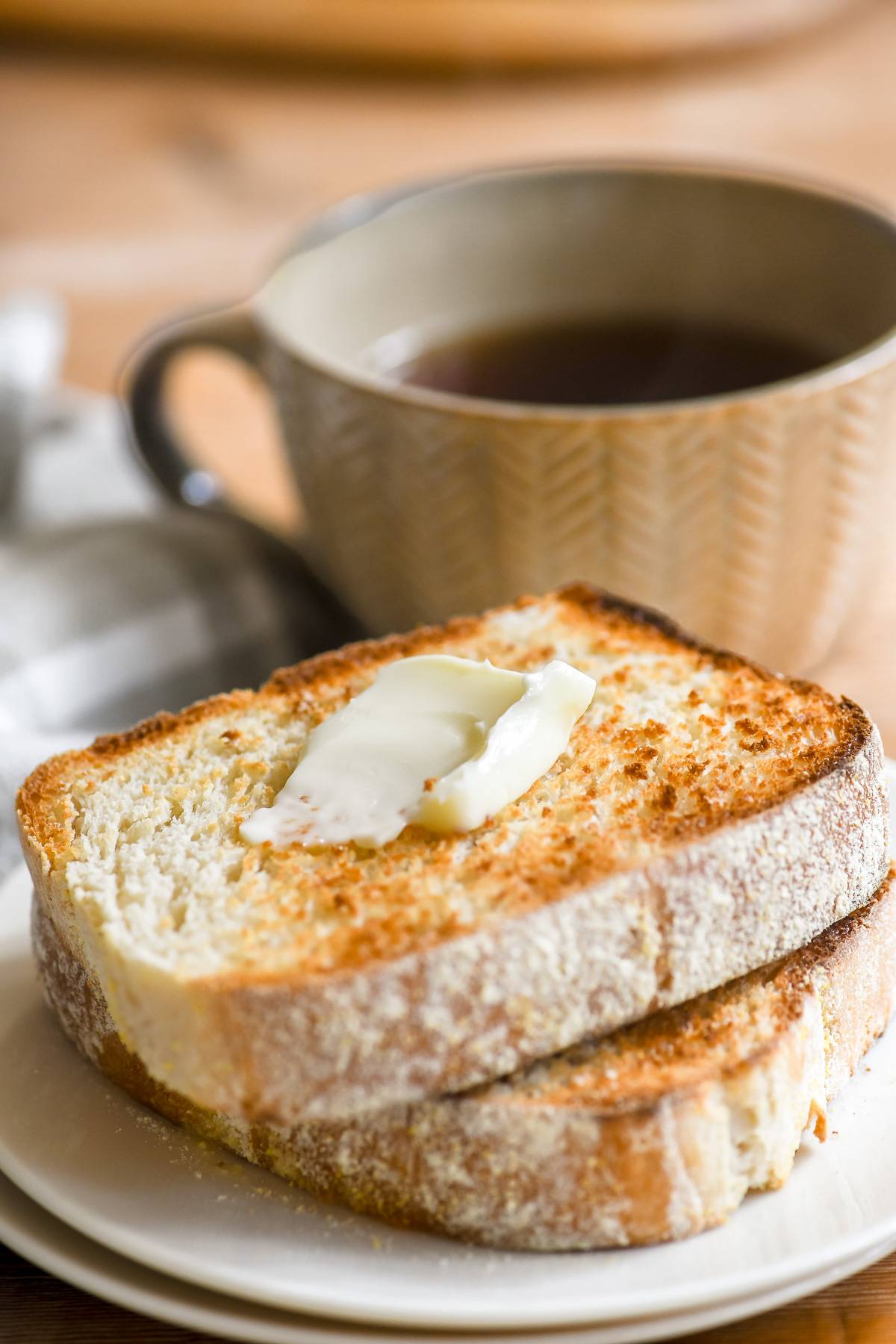 a stack of toasting white bread topped with butter