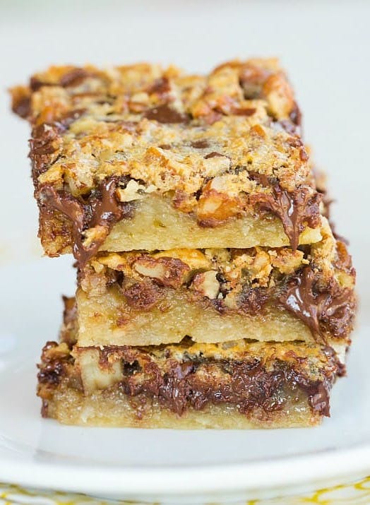 stack of 3 chocolate chip pecan pie bars on a white plate