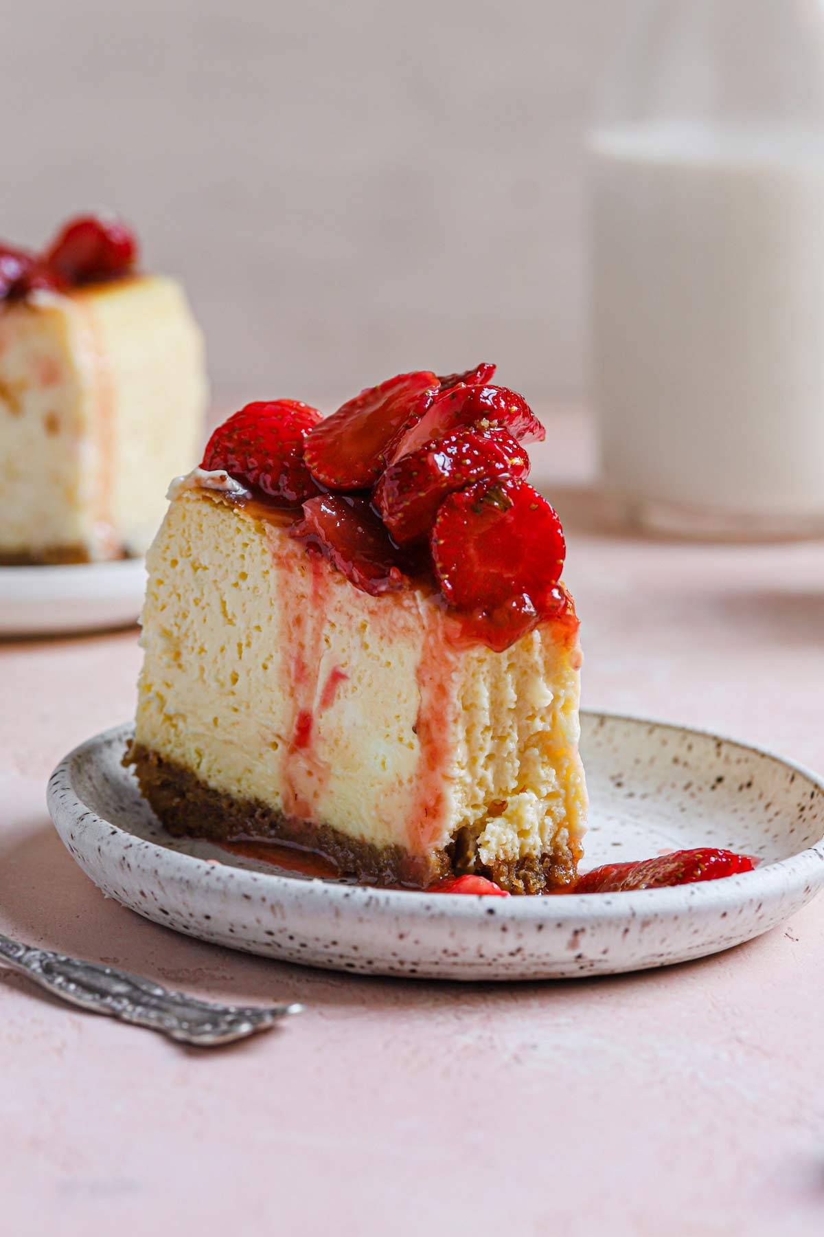 slice of cheesecake topped with strawberries on a plate