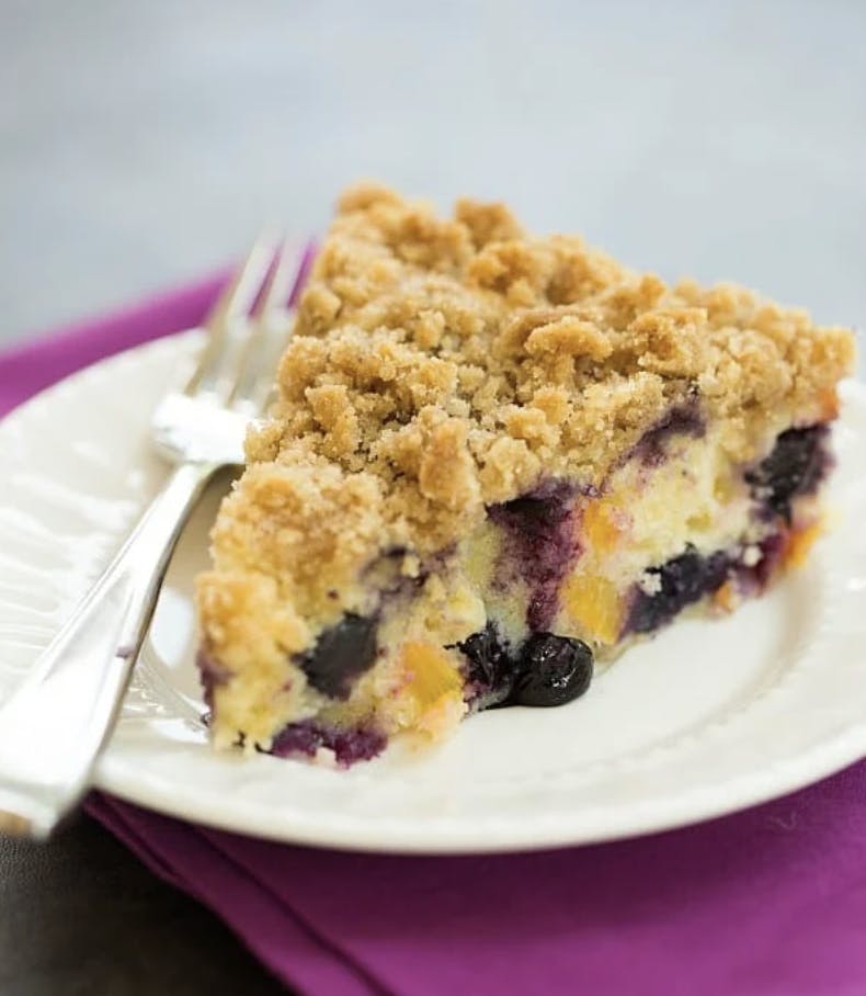 slice of blueberry peach coffee cake on a white plate