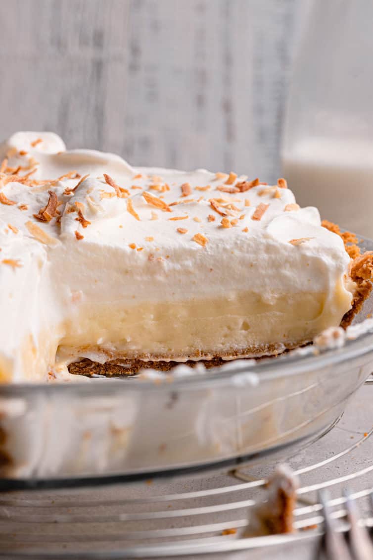 side view of coconut cream pie in a glass pie dish