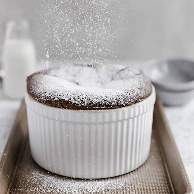 Chocolate souffle in a white ramekin.