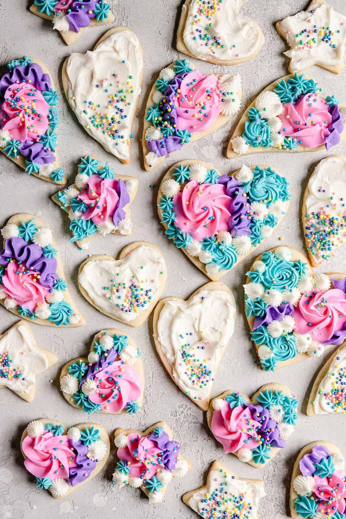 Overhead image of heart sugar cookies decorated with buttercream frosting and sprinkles.