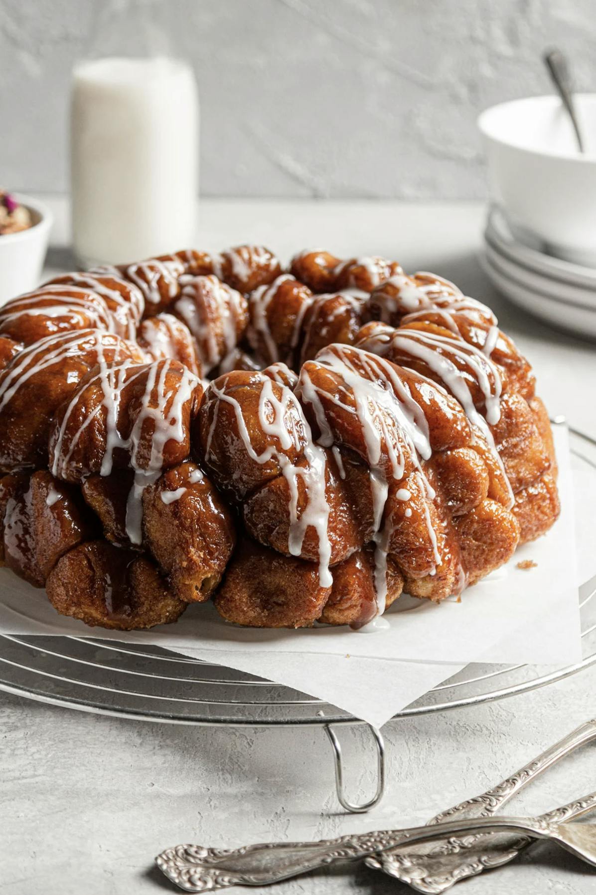 monkey bread on a cooling rack drizzled with vanilla icing