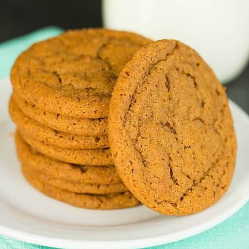 Stack of gingersnap cookies on a white plate.
