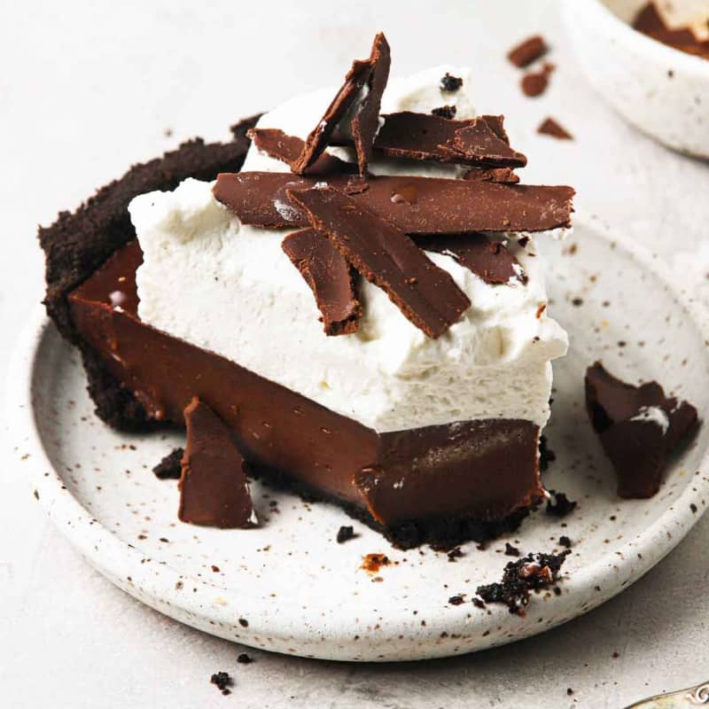 Slice of chocolate cream pie on a white plate.