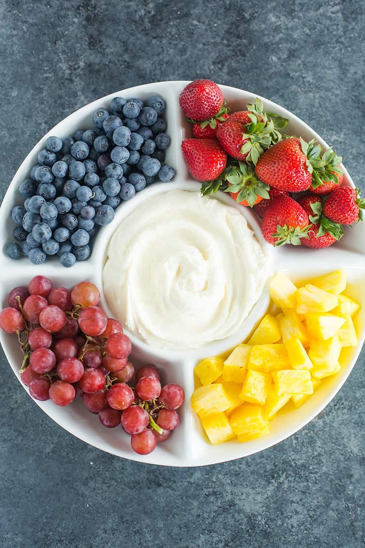 overhead image of a serving tray with cream cheese dip and fresh fruit