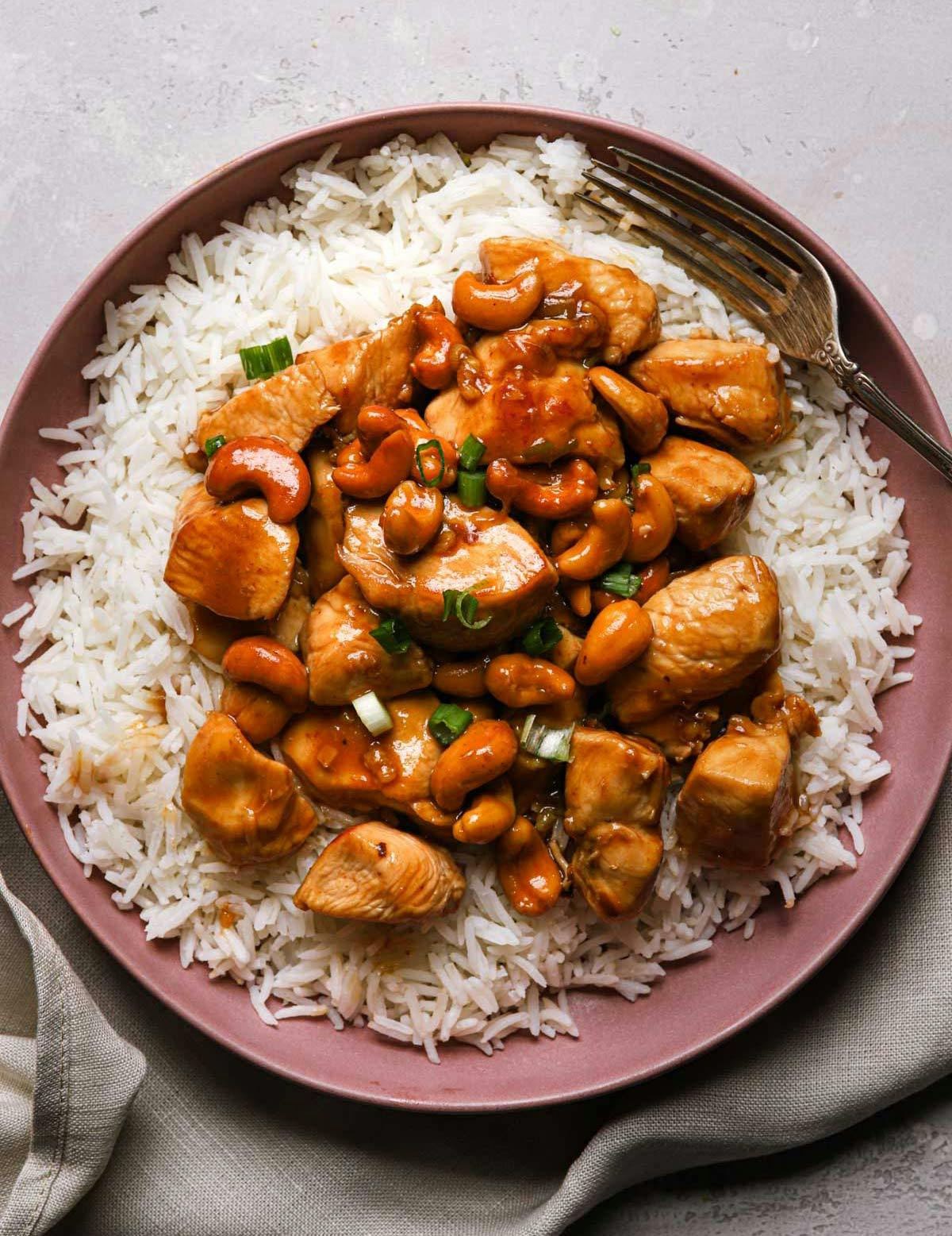 Overhead image of cashew chicken on top of rice on a plate.