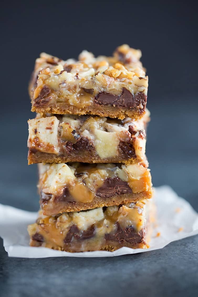 Stack of caramel apple magic bars on a piece of parchment paper.