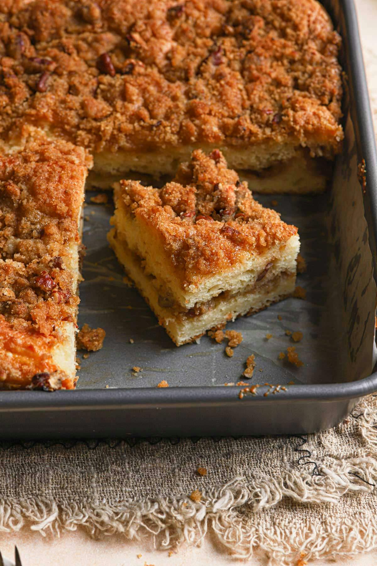 coffee cake in a baking dish featuring a square of cake in the pan