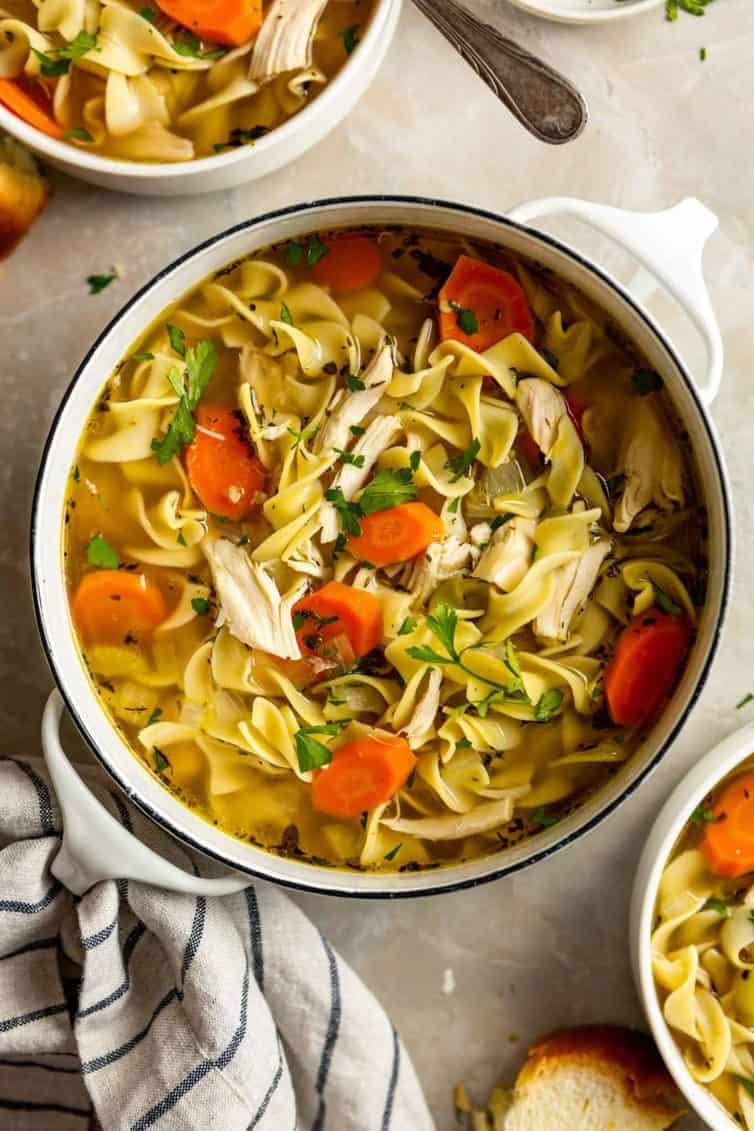 Overhead image of chicken noodle soup in a pot.