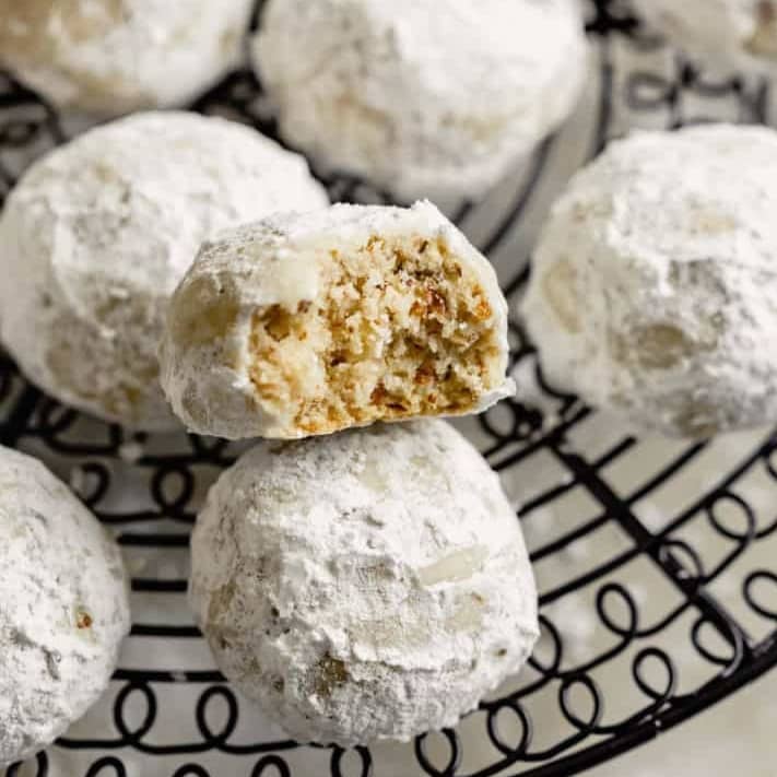 Snowball cookies on a cooling rack.