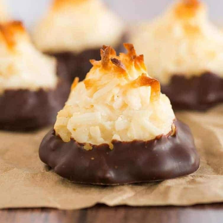 Chocolate dipped coconut macaroon on parchment paper.
