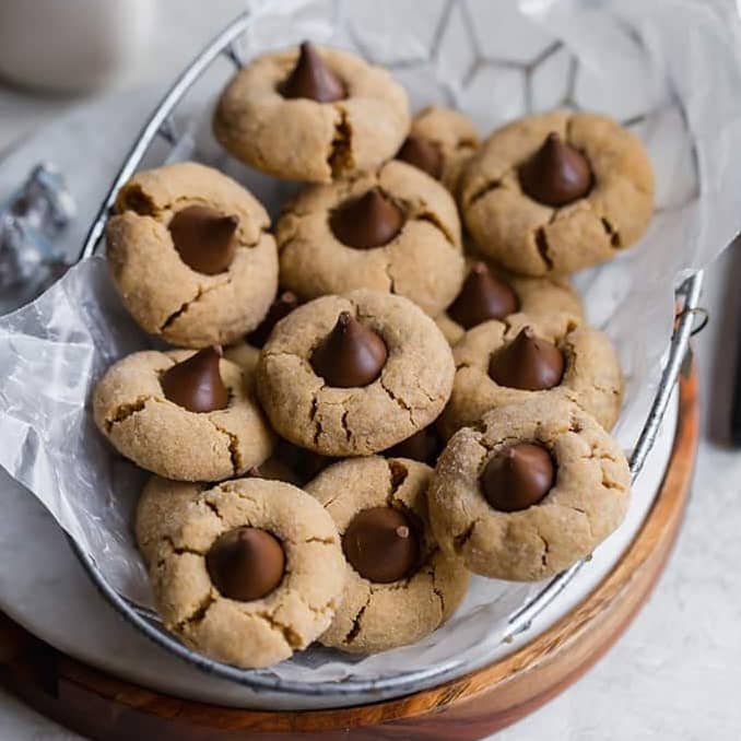 Peanut butter blossom cookies in a basket lined with parchment paper.