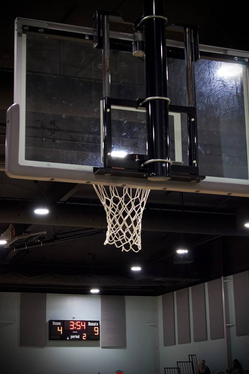 Basketball hoop and scoreboard in gymnasium