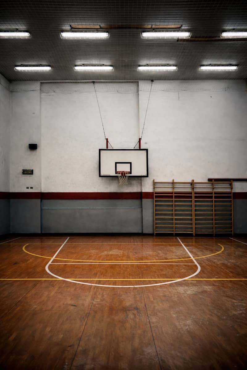 Empty indoor basketball court with wooden floor