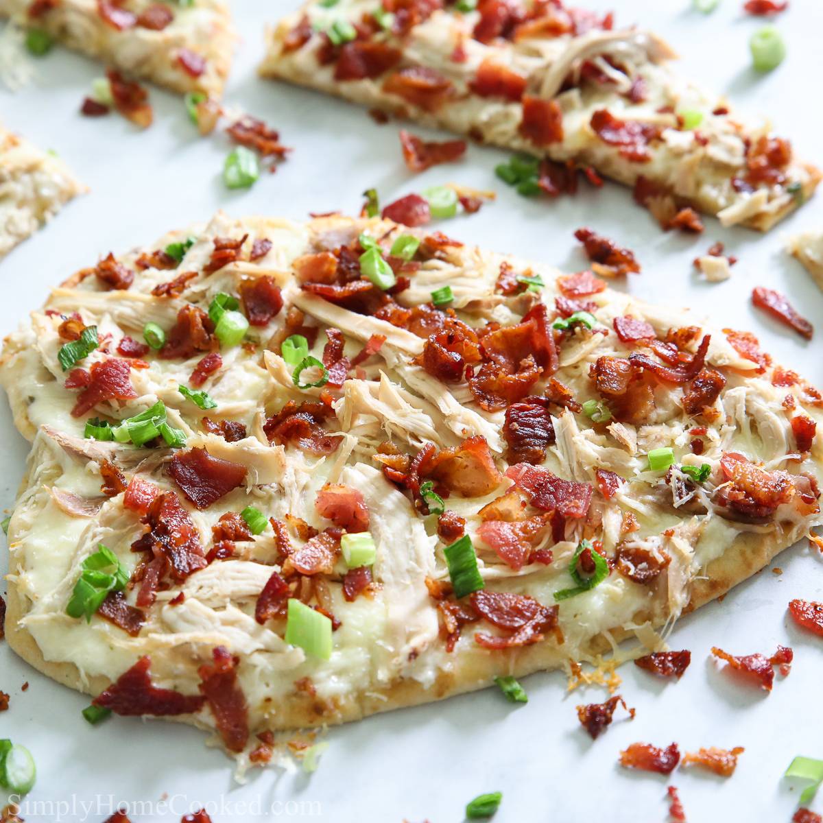 a chicken bacon ranch flatbread pizza with green onion on top