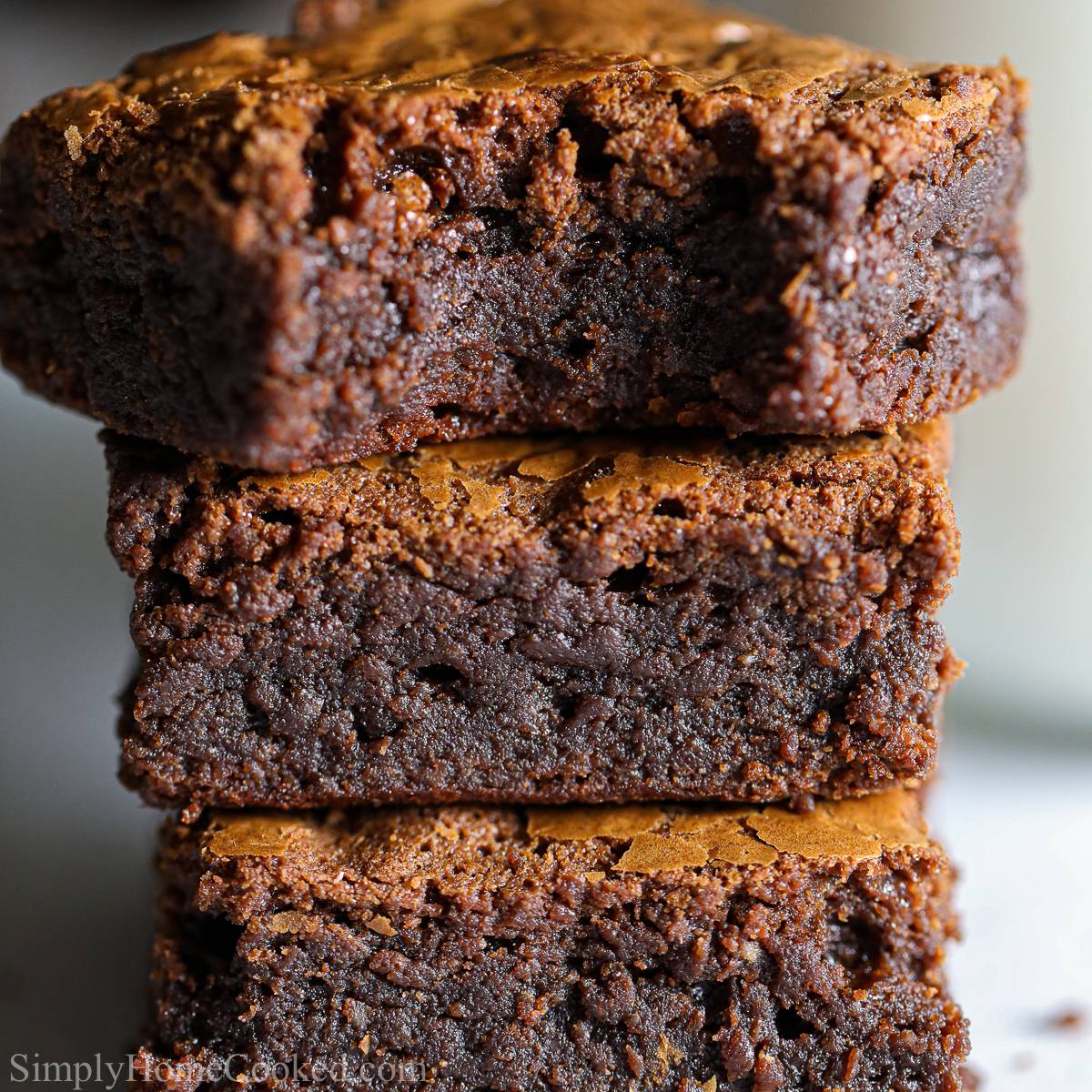 close up image of a stack of fudgey nutella brownies with one bitten into