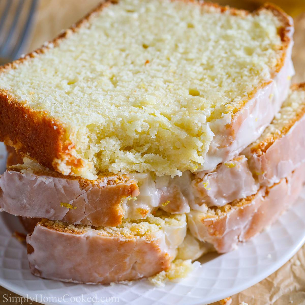 close up image of a stack of sliced iced lemon pound cake