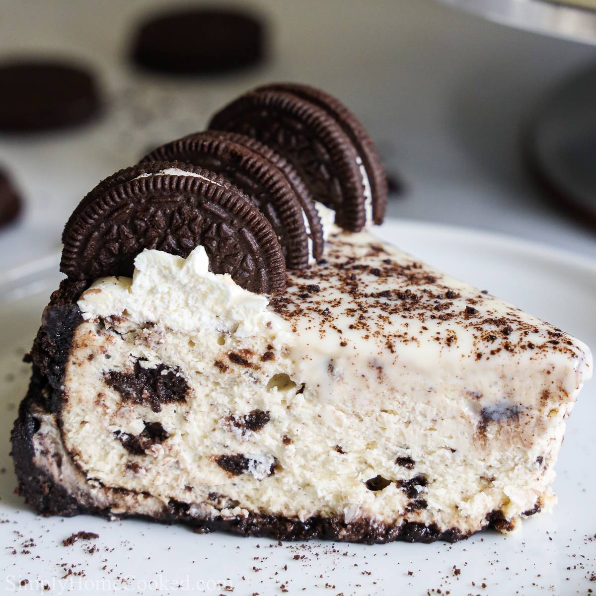 a slice of oreo cheesecake on a white plate with oreos on top