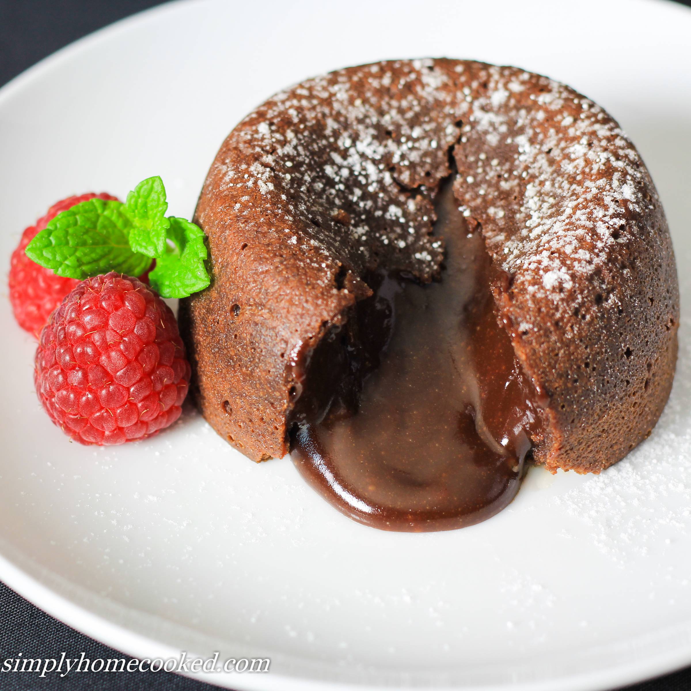 close up image of a cut open chocolate lava cake with chocolate oozing out
