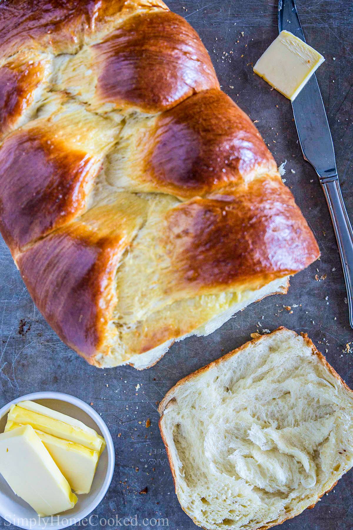 overhead image of homemade brioche bread with a piece sliced off