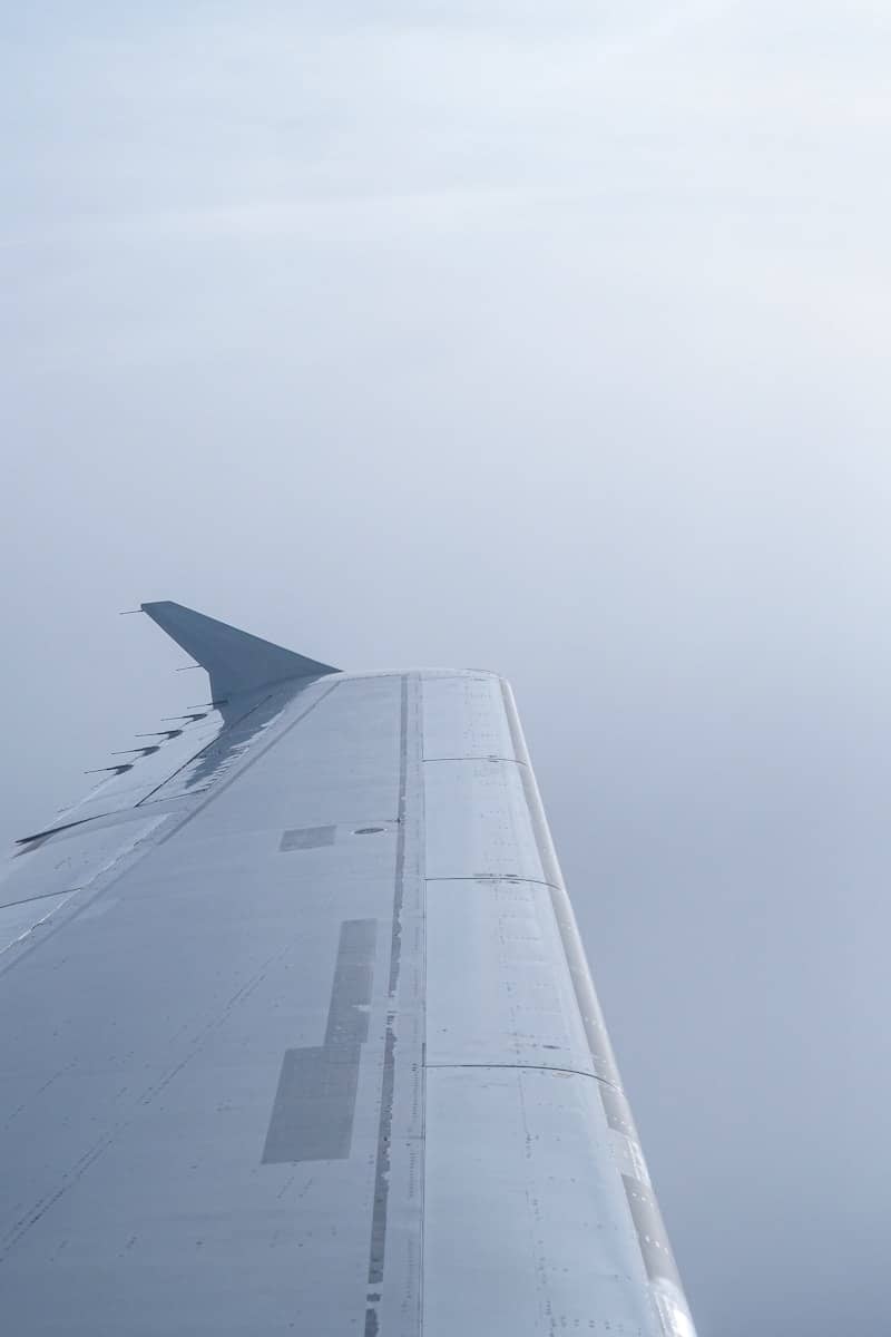 Airplane wing in the cloudy sky.