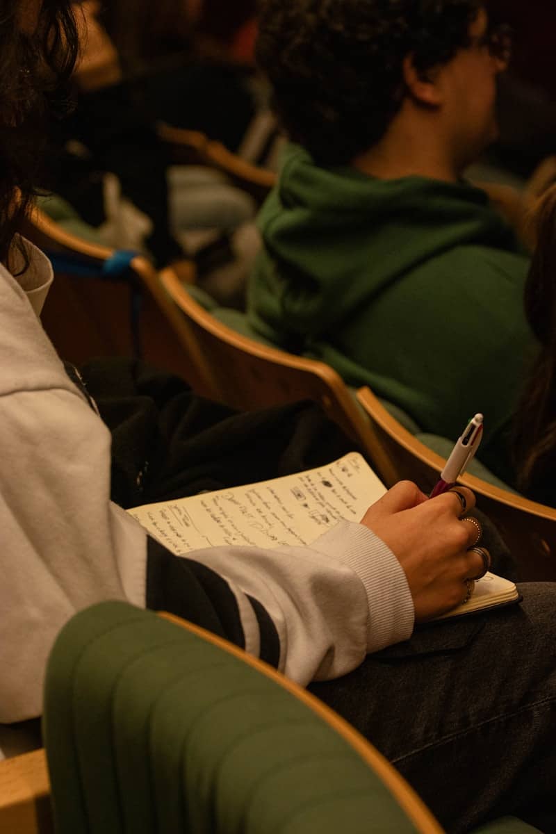 Someone is taking notes during a lecture.