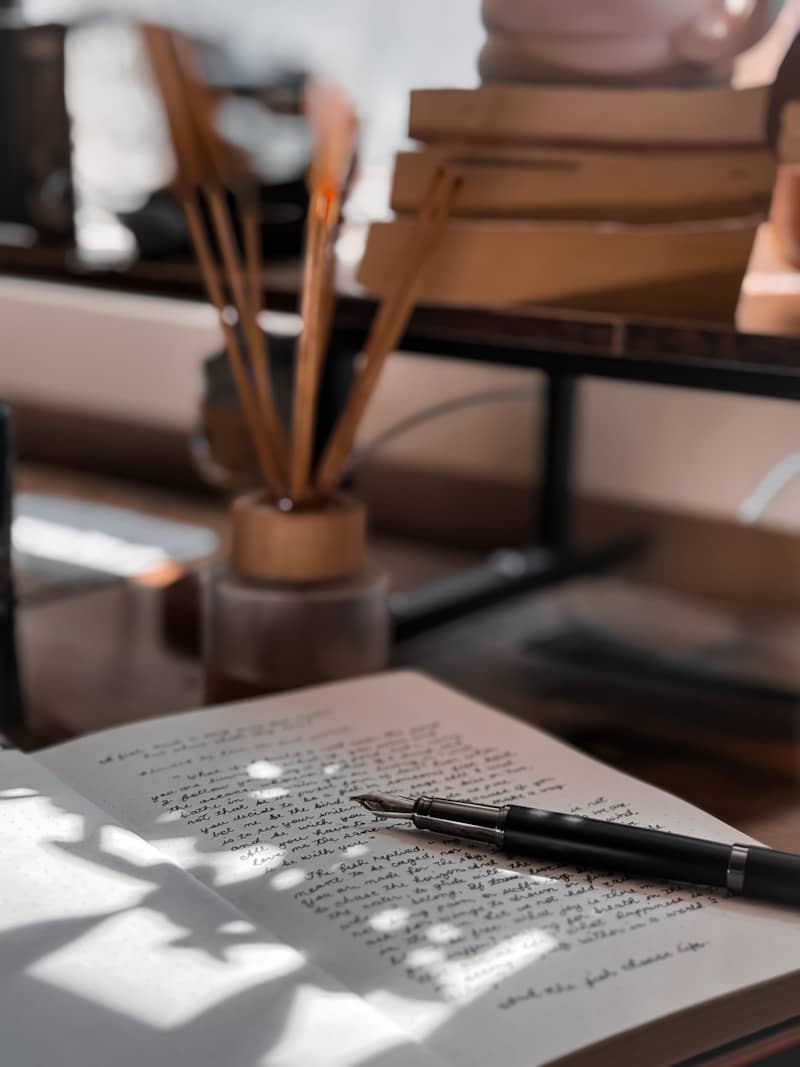 Open book with pen and other stationary.