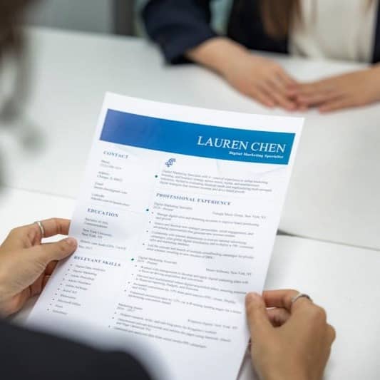 a woman is reading a resume at a table