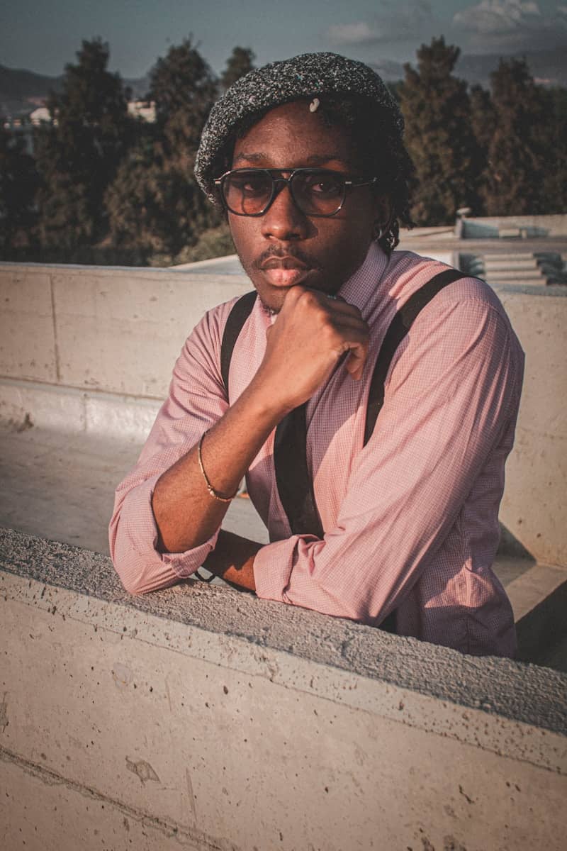 Man in hat and pink shirt with suspenders