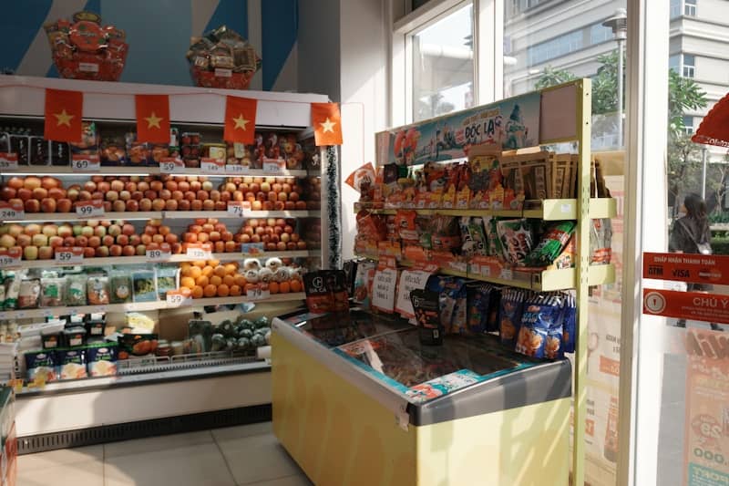 A grocery store aisle with fresh produce and snacks.