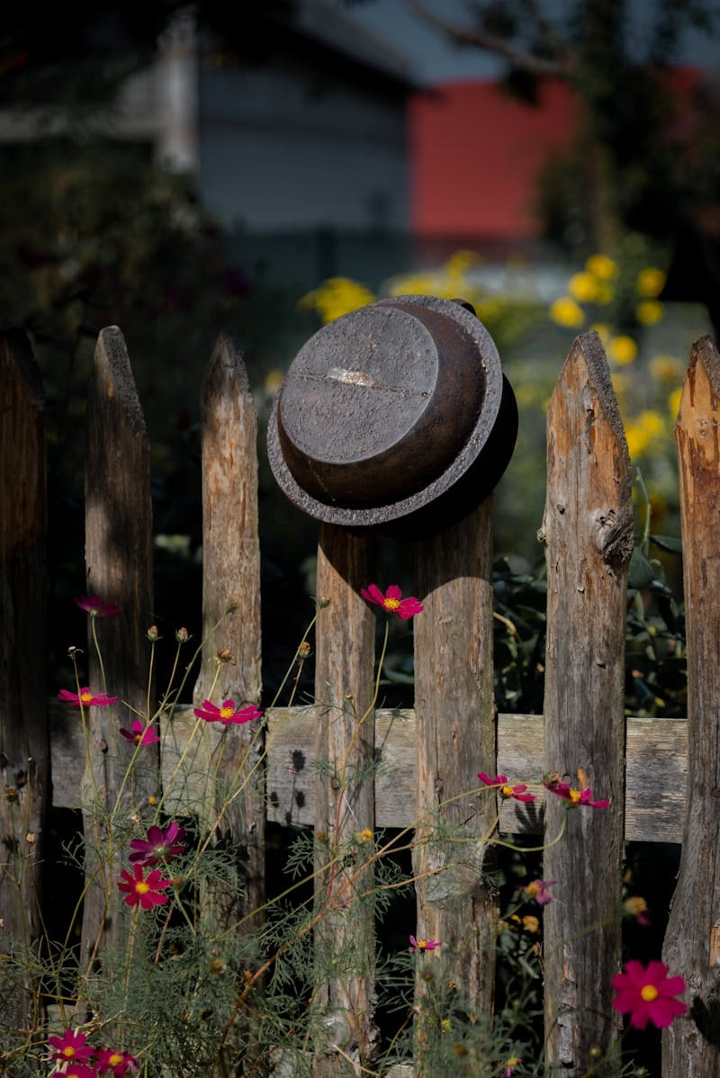 A wooden fence with a hat on top of it