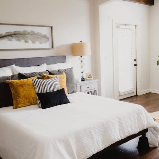 white bed linen near white wooden door