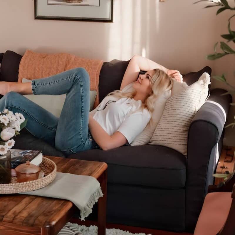 a woman laying on a couch in a living room