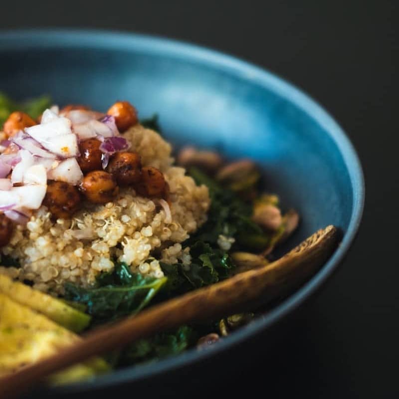 a blue bowl filled with rice and vegetables