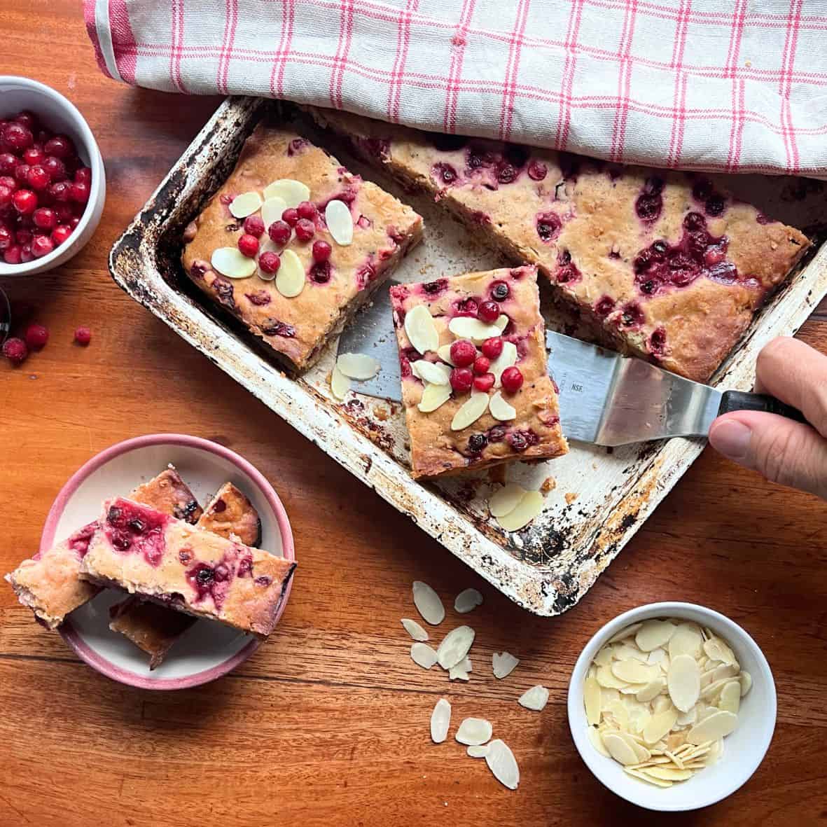 A woman slicing a lingonberry pie.