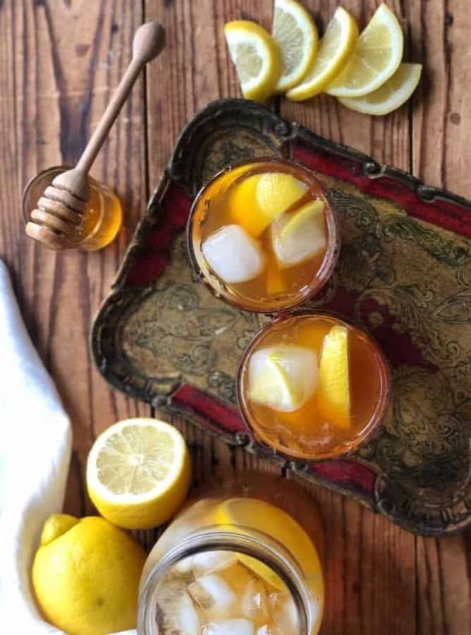 Summery iced teas on a tray with honey and llemon 