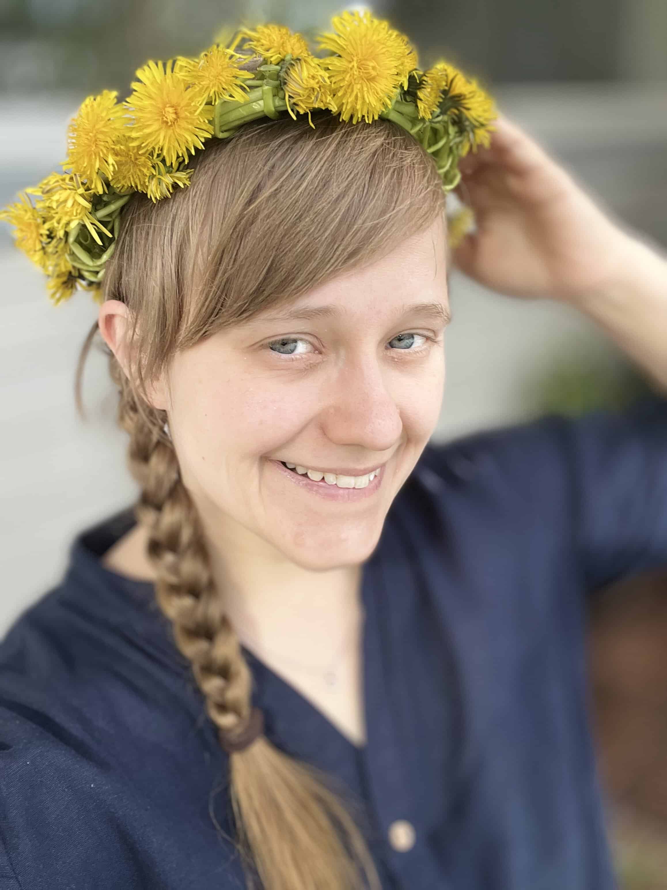 A woman smiling with a flower crown inher head