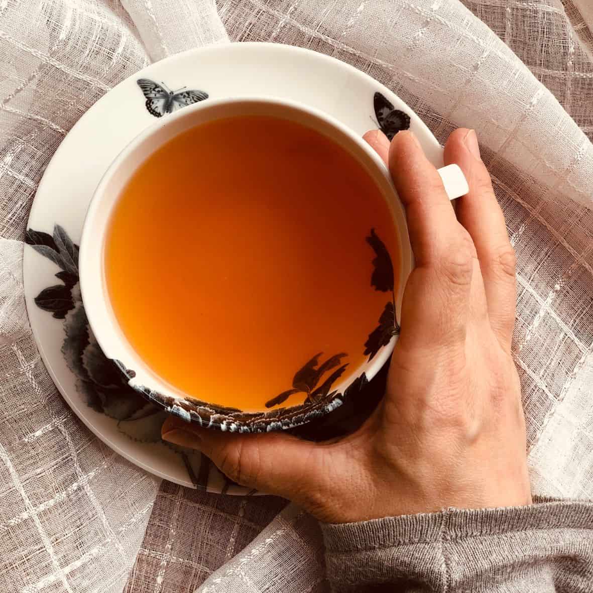 A woman holding a cup of rooibos tea.