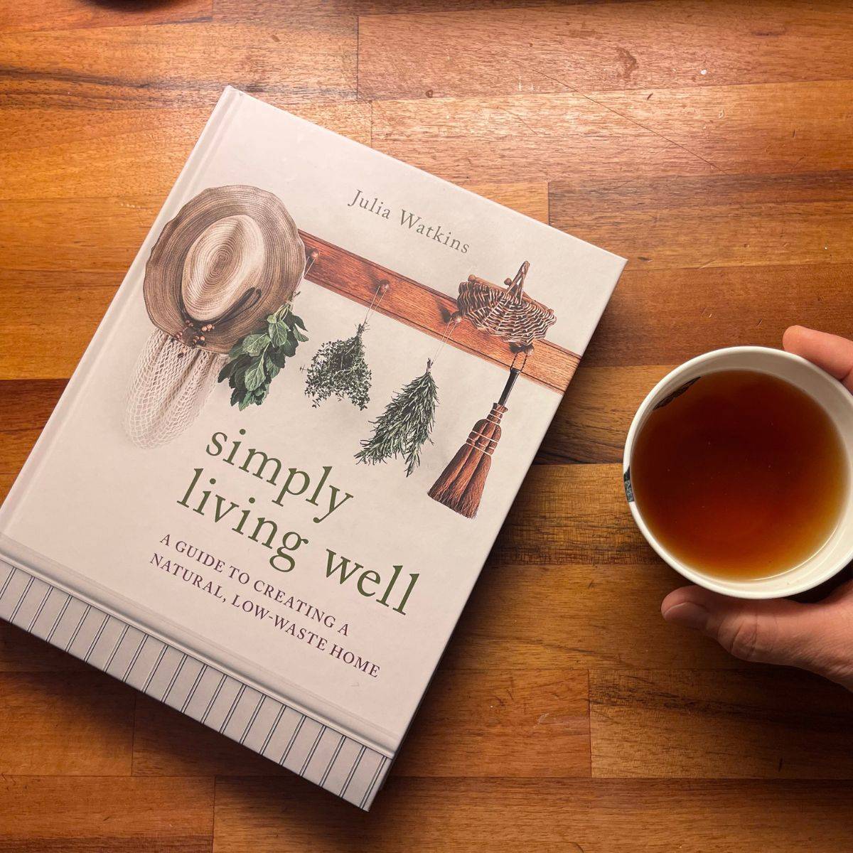 Natural lifestyle resource: Simply living well book with tea cup.