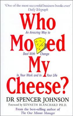 Book cover for Who Moved My Cheese. The v is a piece of cheese and the title is in serif font in red, with black and blue text with author's name and other quotes.