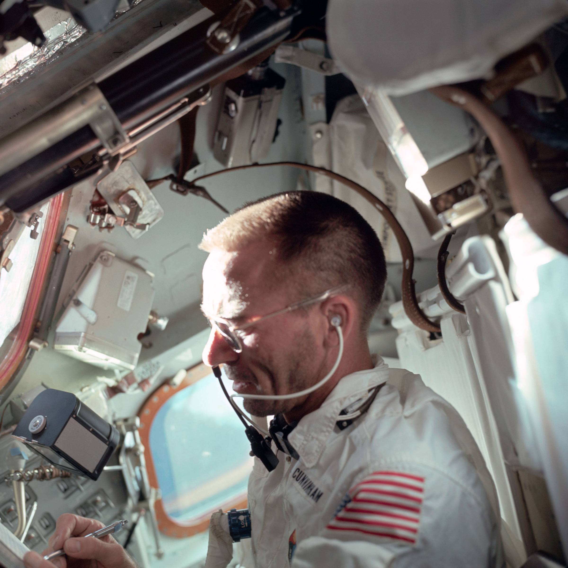 Astronaut Walter Cunningham, Apollo 7 lunar module pilot, writes with space pen as he is photographed performing flight tasks on the ninth day of the Apollo 7 mission.