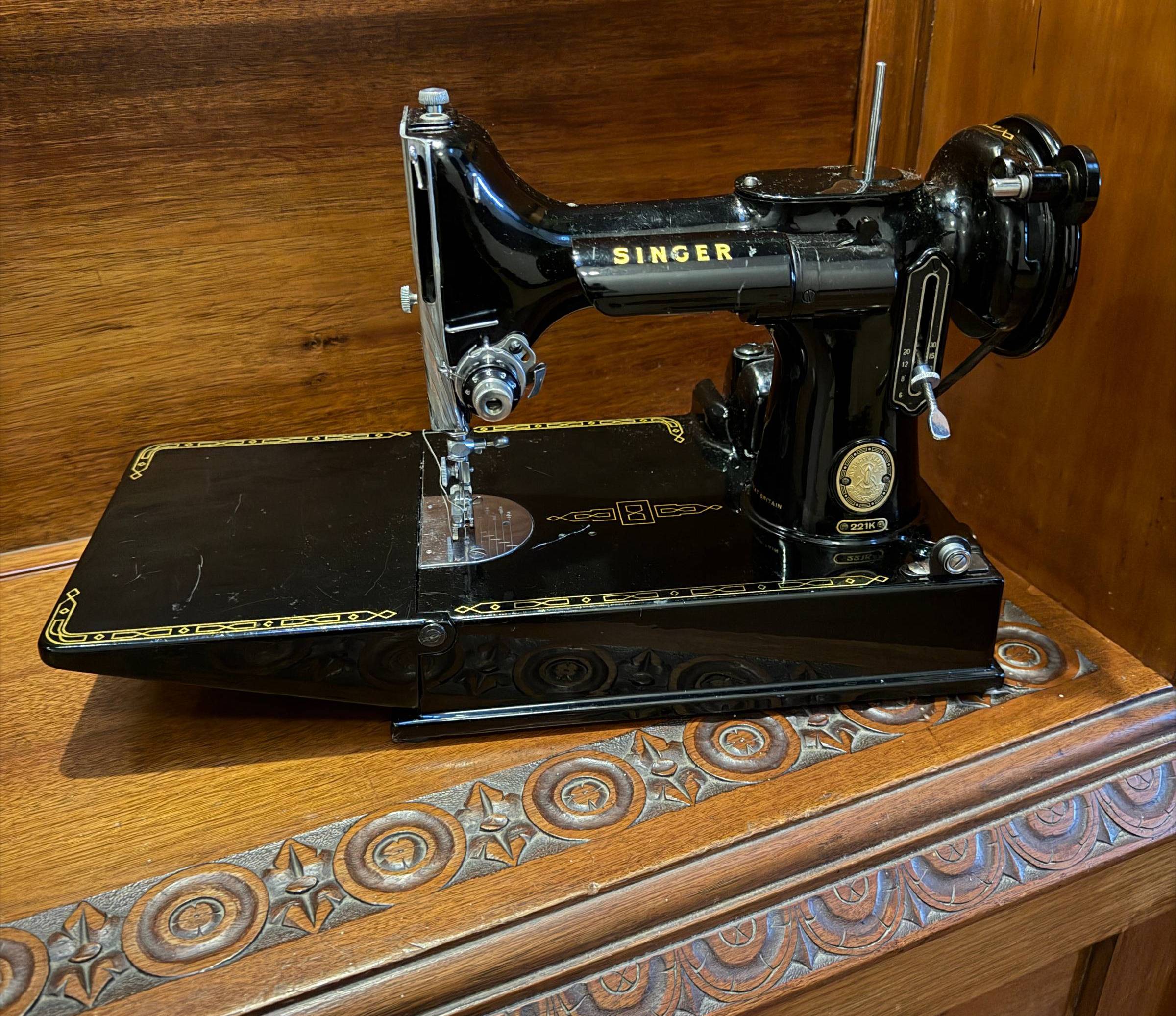 a 1956 Singer Featherweight sewing machine sitting on a wooden bench