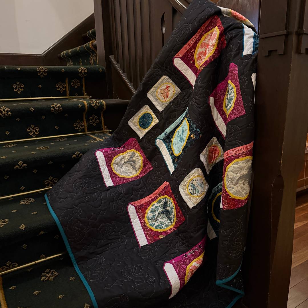 a moody photo of a book quilt draped in a staircase