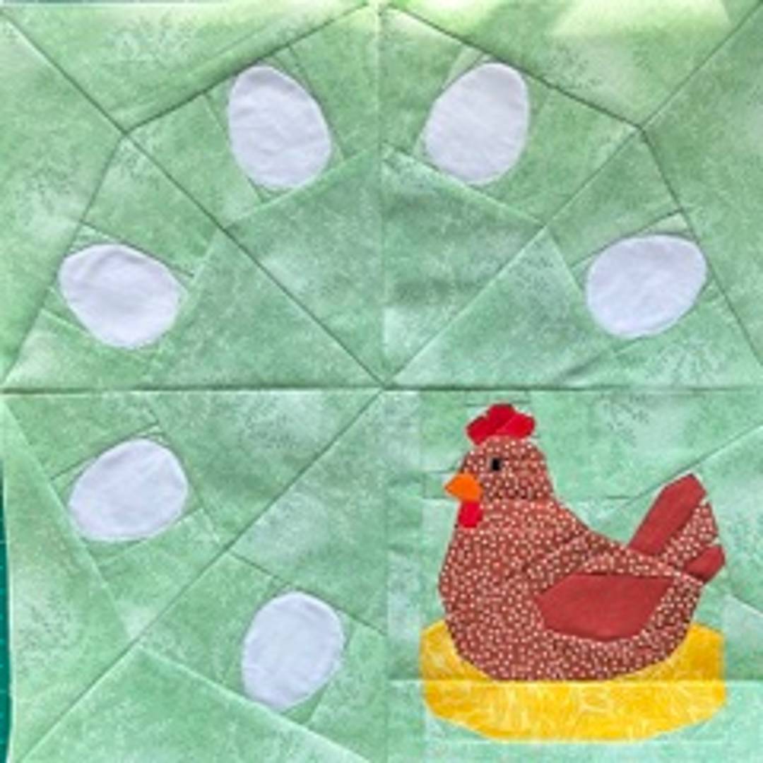 a foundation paper pieced block featuring a chicken and eggs in a wreath style on a green background