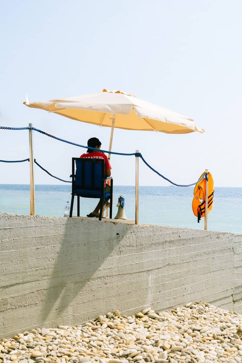 A man sitting in a chair under an umbrella